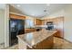 Kitchen with black appliances, wooden cabinetry and large center island at 1186 E Bradstock Way, San Tan Valley, AZ 85140