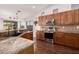 Well-lit kitchen featuring wood cabinets, stainless steel appliances, granite countertops, and a breakfast bar at 13804 W Marshall Ave, Litchfield Park, AZ 85340