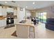 Open-concept kitchen featuring stainless steel appliances, an island with seating, and a view to the backyard at 16738 W Rio Vista Ln, Goodyear, AZ 85338