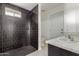 Modern bathroom featuring sleek, dark tiled shower and stylish vanity at 1713 E Westchester Dr, Tempe, AZ 85283