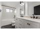 Modern bathroom with dual sinks, marble countertops, a tub, and black hardware at 1713 E Westchester Dr, Tempe, AZ 85283