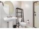 Bathroom with pedestal sink, wall shelving, toilet and clear glass shower with black hardware at 1752 N Harper --, Mesa, AZ 85207