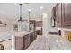 Open kitchen featuring a large island with seating, stainless steel appliances, and dark wood cabinets at 1752 N Harper --, Mesa, AZ 85207