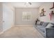 Living room with a plush gray couch, carpeted floors, floating shelves, and a closet at 1752 N Harper --, Mesa, AZ 85207