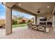 Relaxing covered patio overlooking the landscaped yard with a TV and comfortable seating area, perfect for outdoor enjoyment at 1752 N Harper --, Mesa, AZ 85207