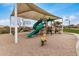Playground equipment, including a slide and spring rider, under a large shade structure with safety surfacing at 1752 N Harper --, Mesa, AZ 85207