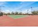 Spacious tennis court with a new net surrounded by desert landscaping and sky at 1752 N Harper --, Mesa, AZ 85207