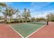 Well-maintained tennis court with green and red surface, surrounded by mature trees at 1752 N Harper --, Mesa, AZ 85207