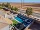 Aerial view of the backyard featuring a pool, spa, basketball court, and trampoline at 20867 N Grantham Rd, Maricopa, AZ 85138