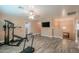 Bonus room with modern laminate flooring, ample space, and natural light with stairs to the second floor at 20867 N Grantham Rd, Maricopa, AZ 85138