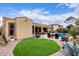 Well-maintained backyard with green lawn, desert landscaping, pool, and covered patio at 21842 E Via De Olivos --, Queen Creek, AZ 85142