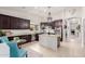 Bright kitchen features dark cabinetry, granite counters, an island, stainless appliances, and a decorative chandelier at 21842 E Via De Olivos --, Queen Creek, AZ 85142