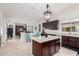 Open concept kitchen with granite island, dark cabinets, stainless steel appliances, and a view to the dining area at 21842 E Via De Olivos --, Queen Creek, AZ 85142