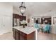Spacious kitchen featuring granite island with seating, stainless refrigerator, and adjacent dining area with blue chairs at 21842 E Via De Olivos --, Queen Creek, AZ 85142
