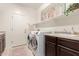 Bright laundry room features front load washer and dryer, storage cabinet, and utility sink at 21842 E Via De Olivos --, Queen Creek, AZ 85142