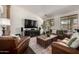 Comfortable living room featuring leather furniture, a wooden coffee table, and ample natural light from the windows at 21842 E Via De Olivos --, Queen Creek, AZ 85142