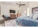 Comfortable main bedroom offers a ceiling fan, accent furniture and a view to the en-suite bathroom at 21842 E Via De Olivos --, Queen Creek, AZ 85142