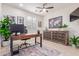 Cozy home office featuring wooden desk, decorative cabinet, ceiling fan, and a large window for natural light at 21842 E Via De Olivos --, Queen Creek, AZ 85142