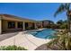 Inviting pool with a rock waterfall feature, set against a backdrop of mature landscaping and a covered patio at 21842 E Via De Olivos --, Queen Creek, AZ 85142