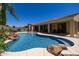 Scenic pool with a cascading waterfall feature, complemented by manicured landscaping and a spacious covered patio at 21842 E Via De Olivos --, Queen Creek, AZ 85142