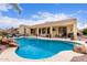 Resort-style backyard pool with rock features, lush landscaping, and a covered patio, perfect for outdoor entertaining and relaxation at 21842 E Via De Olivos --, Queen Creek, AZ 85142