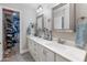Bathroom vanity with double sinks and cabinets, next to a closet at 22102 W Ripple Rd, Buckeye, AZ 85326