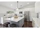 Bright kitchen features stainless steel appliances, white cabinets, gray island with seating, and white subway tile backsplash at 2770 W Kent Dr, Chandler, AZ 85224