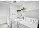 Well-lit laundry room with washer, dryer, and convenient shelving for storage at 2770 W Kent Dr, Chandler, AZ 85224