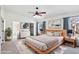 Bright main bedroom featuring a wooden bed frame, ensuite bathroom, and a ceiling fan with integrated lighting at 2770 W Kent Dr, Chandler, AZ 85224