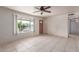 Bright living room with tile floors, neutral paint, large window, ceiling fan and a wooden front door at 3238 E Cholla St, Phoenix, AZ 85028