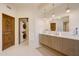 Bright bathroom featuring a double vanity, wood accents, and in-unit washer and dryer for added convenience at 40915 N 107Th Pl, Scottsdale, AZ 85262