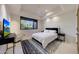 Modern bedroom with a sleek black bed frame, white bedding, and a large window overlooking nature at 40915 N 107Th Pl, Scottsdale, AZ 85262
