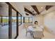 Cozy dining room featuring a stone fireplace, wooden beams, and picturesque mountain views through large windows at 40915 N 107Th Pl, Scottsdale, AZ 85262