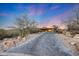 Elegant home with an extended paver driveway and serene desert landscaping, set against a vibrant sunset backdrop at 40915 N 107Th Pl, Scottsdale, AZ 85262