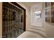 Modern wine cellar behind glass doors with temperature control and custom racking at 40915 N 107Th Pl, Scottsdale, AZ 85262