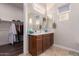 Bathroom featuring double sinks, vanity, large mirror, and spacious walk-in closet at 41737 W Cribbage Rd, Maricopa, AZ 85138