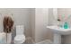 Cozy powder room features pedestal sink, toilet, and neutral colors at 41737 W Cribbage Rd, Maricopa, AZ 85138