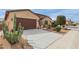Wide concrete driveway leading to a two-car garage, surrounded by desert landscaping and green cacti at 41737 W Cribbage Rd, Maricopa, AZ 85138