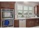 Kitchen features stainless appliances, double ovens, tile flooring, granite counters, and modern finishes at 41737 W Cribbage Rd, Maricopa, AZ 85138