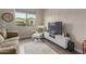 Living room with new hardwood flooring, couch, TV, large window and contemporary furniture at 41737 W Cribbage Rd, Maricopa, AZ 85138