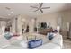Bright and airy living room with a white sofa, glass coffee table, and views into other living spaces at 41737 W Cribbage Rd, Maricopa, AZ 85138