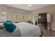 Spacious main bedroom with a large window, accent lighting, hardwood floors, and accent chair at 41737 W Cribbage Rd, Maricopa, AZ 85138