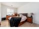 Traditional bedroom with wood-look floors, a large window, and a black accent blanket over a neatly made bed at 4438 N 27Th St # 24, Phoenix, AZ 85016
