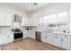 Bright, spacious kitchen featuring white cabinets, stainless steel appliances, and a view of the sink and windows at 4438 N 27Th St # 24, Phoenix, AZ 85016