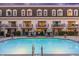 Community pool with lounge chairs in front of condo building with balconies and a brown roof at 4438 N 27Th St # 24, Phoenix, AZ 85016