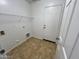 A clean laundry room with tile floors, wire shelving, and utility connections at 4669 E Sierrita Rd, San Tan Valley, AZ 85143