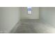 Empty bedroom featuring fresh paint, a single window, and concrete floors ready for carpet or your choice of flooring at 46940 W Coe St, Maricopa, AZ 85139