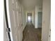 Inviting hallway showcasing wood-look flooring, freshly painted white walls, and views of rooms at the end of the hallway at 46940 W Coe St, Maricopa, AZ 85139