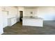 Bright, open kitchen with white cabinets, a large center island, neutral countertops, and modern fixtures at 46940 W Coe St, Maricopa, AZ 85139
