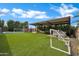 Lush backyard featuring a trampoline, playset, hammock under covered patio, and lush landscaping at 5172 S Seton Ave, Gilbert, AZ 85298